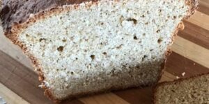 Sliced homemade bread on wooden cutting board.