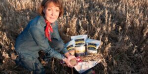 Woman in field with packaged grains.