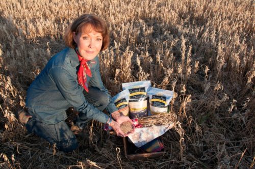 Woman in field with packaged grains.
