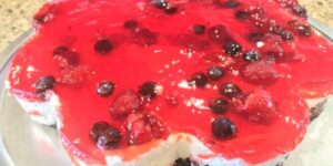 Red berry cheesecake with a shiny glaze.