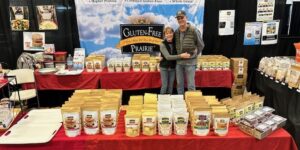 Vendor showcasing a variety of flavored popcorn at a market stall.