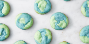 Colorful round cookies with blue and green swirls on a white surface.