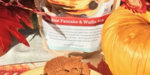 Pumpkin-shaped cookies next to a pumpkin and fall decorations.