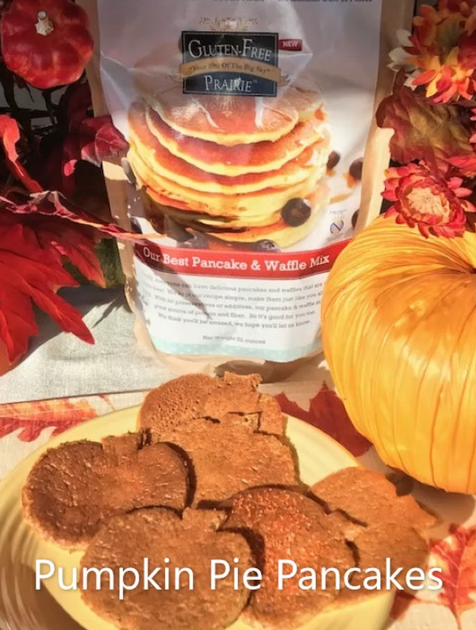 Pumpkin-shaped cookies next to a pumpkin and fall decorations.