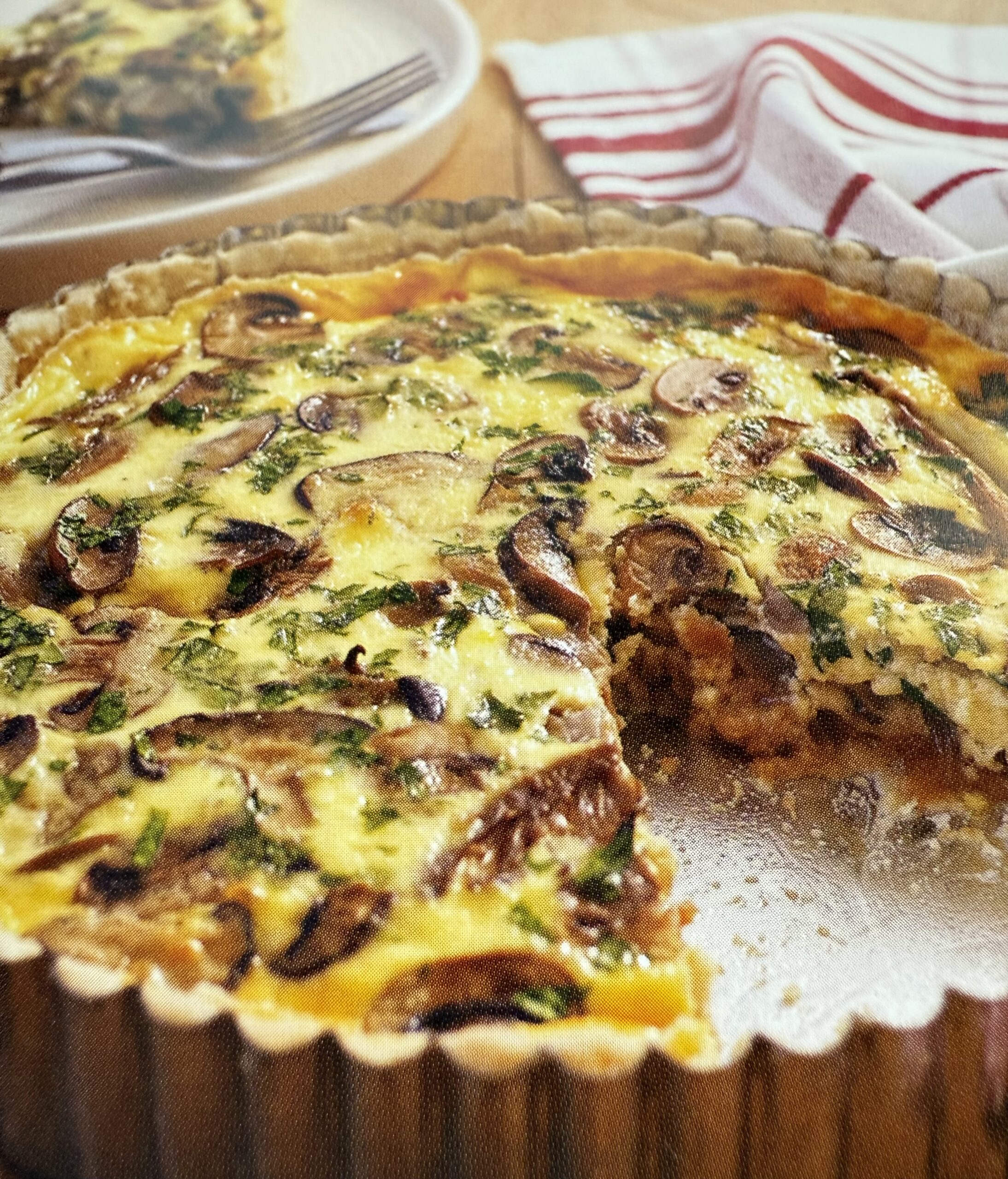 Close-up of a savory quiche with mushrooms and cheese.