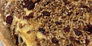 Close-up of a pecan-topped dessert pizza with a golden crust.